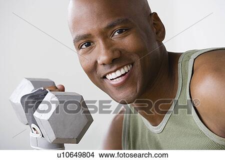 Portrait of smiling young man lifting dumbbell View Large Photo Image Picture - Portrait of smiling young man lifting dumbbell. Fotosearch