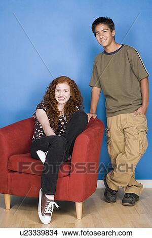 Portrait of teenage (16-17) girl and teenage boy (16-17) sitting together View Large Photo Image Picture - Portrait of teenage (16-17) girl and teenage boy (16-17) sitting together. Fotosearch