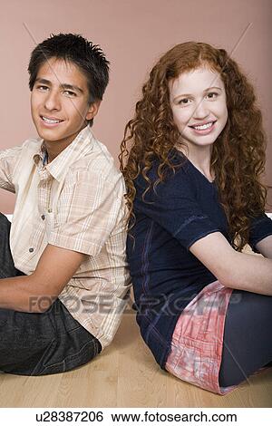 Portrait of teenage (16-17) girl and teenage boy (16-17) sitting together View Large Photo Image Stock Photograph - Portrait of teenage (16-17) girl and teenage boy (16-17) sitting together. Fotosearch