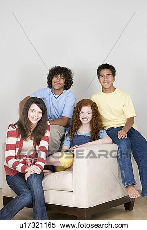 Stock Photography - Portrait of teenagers (14-15, 16-17) sitting on armchair. Fotosearch