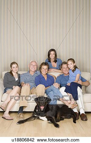 Stock Image - Portrait of three-generation family with two girls (8-9, 14-15) and dog. Fotosearch