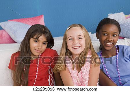 Stock Image - Portrait of three girls (10-11) at slumber party. Fotosearch