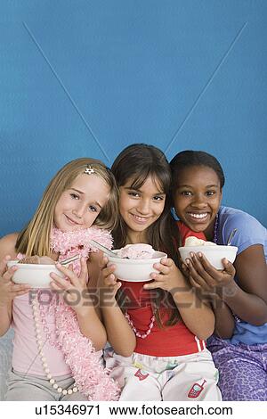 Portrait of three girls (10-11) holding desserts at slumber party View Large Photo Image Stock Image - Portrait of three girls (10-11) holding desserts at slumber party. Fotosearch