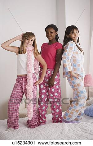 Portrait of three girls (10-11) standing on bed at slumber party View Large Photo Image Stock Image - Portrait of three girls (10-11) standing on bed at slumber party. Fotosearch