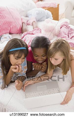 Portrait of three girls (10-11)using laptop View Large Photo Image Stock Photo - Portrait of three girls (10-11)using laptop. Fotosearch