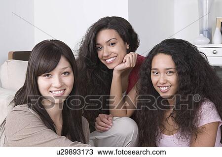 Stock Image - Portrait of three young women smiling. Fotosearch