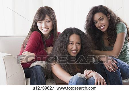 Stock Photo - Portrait of three young women smiling. Fotosearch