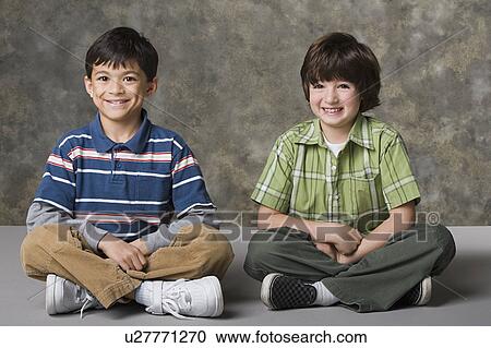 Stock Image - Portrait of two boys (6-7, 8-9) smiling, studio shot. Fotosearch