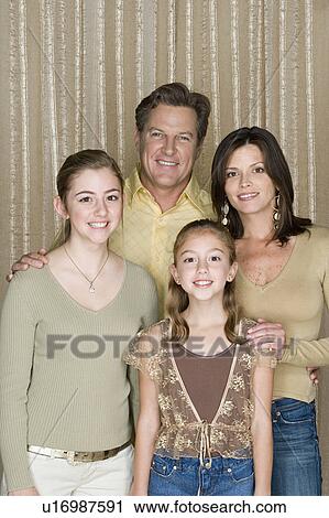 Stock Image - Portrait of two generation family with two daughters (8-9, 14-15). Fotosearch