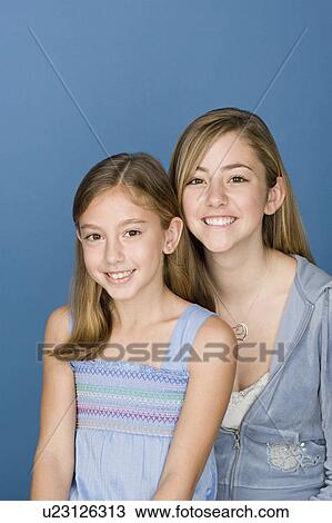 Stock Image - Portrait of two sisters (14-15, 8-9). Fotosearch