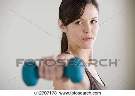 Portrait of woman lifting dumbbell View Large Photo Image Stock Photo - Portrait of woman lifting dumbbell. Fotosearch