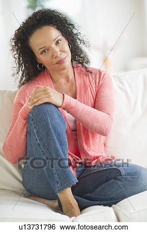 Portrait of woman sitting on sofa View Large Photo Image Stock Photograph - Portrait of woman sitting on sofa. Fotosearch