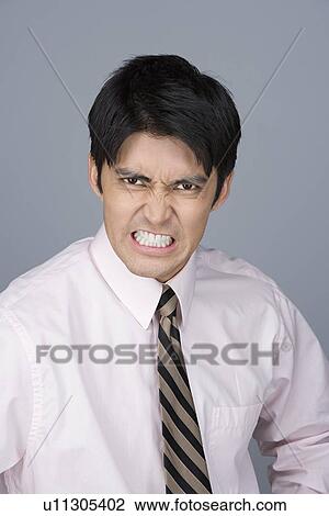 Portrait of young businessman pulling funny faces View Large Photo Image Stock Image - Portrait of young businessman pulling funny faces. Fotosearch