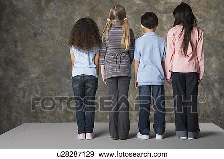 Rear view of children (8-9) standing, studio shot View Large Photo Image Stock Photo - Rear view of children (8-9) standing, studio shot. Fotosearch
