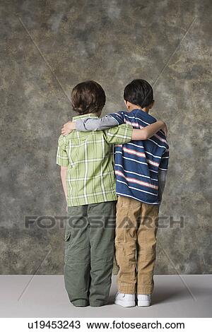 Rear view of two boys (6-7, 8-9) standing together, studio shot View Large Photo Image Stock Image - Rear view of two boys (6-7, 8-9) standing together, studio shot. Fotosearch