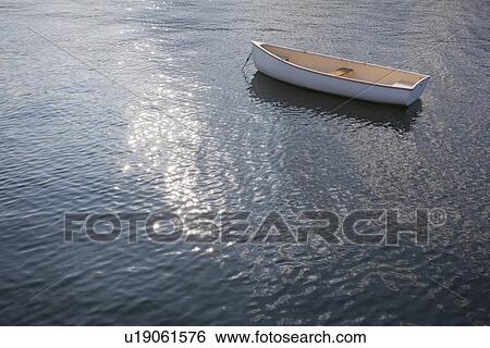 Stock Photograph - Rhode Island, Lonely rowing boat on water. Fotosearch