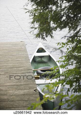 Stock Image - Roaring Brook Lake, Boat moored at pier on lake. Fotosearch