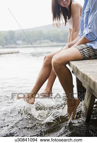 Roaring Brook Lake, Close up of couple sitting on pier by lake View Large Photo Image Picture - Roaring Brook Lake, Close up of couple sitting on pier by lake. Fotosearch