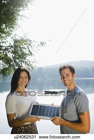 Roaring Brook Lake, Couple holding solar panel View Large Photo Image Stock Image - Roaring Brook Lake, Couple holding solar panel. Fotosearch