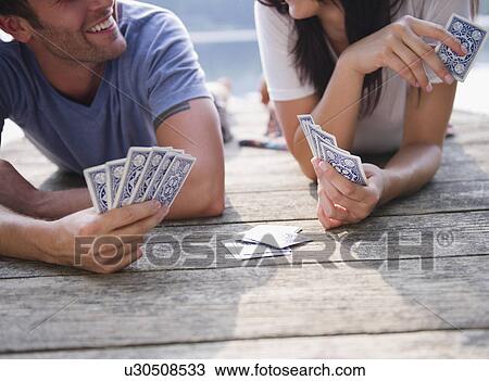 Stock Image - Roaring Brook Lake, Couple playing cards on pier. Fotosearch