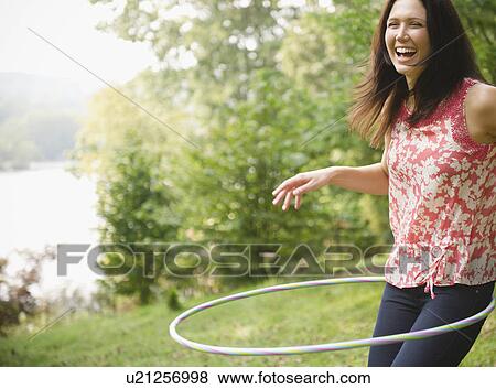 Stock Photo - Roaring Brook Lake, Woman plying with hoopla hoop. Fotosearch