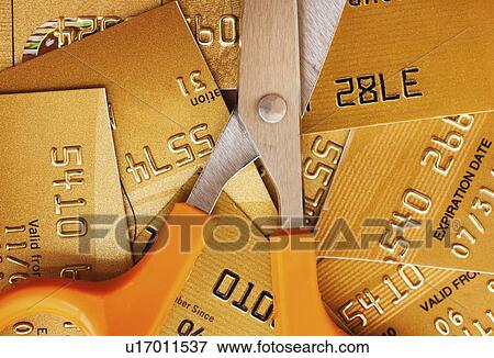 Stock Photo - Scissors on pile of credit cards, studio shot. Fotosearch
