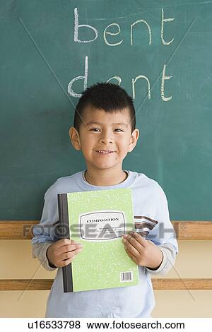 Smiling boy (6-7) showing notebook in classroom View Large Photo Image Stock Photo - Smiling boy (6-7) showing notebook in classroom. Fotosearch