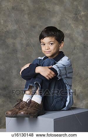 Stock Photo - Smiling boy (8-9) standing, studio shot. Fotosearch