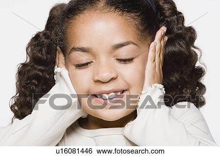 Smiling girl (8-9) covering her ears, studio shot View Large Photo Image Stock Photograph - Smiling girl (8-9) covering her ears, studio shot. Fotosearch