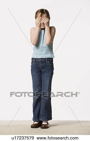 Smiling girl (8-9) covering her eyes, studio shot View Large Photo Image Stock Photo - Smiling girl (8-9) covering her eyes, studio shot. Fotosearch