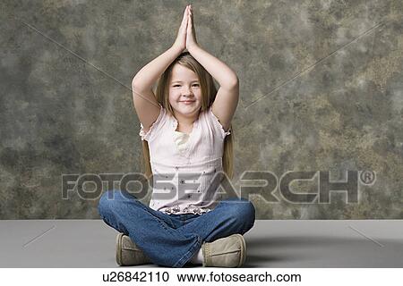 Smiling girl (8-9) sitting cross-legged with hand over her head, studio shot View Large Photo Image Stock Image - Smiling girl (8-9) sitting cross-legged with hand over her head, studio shot. Fotosearch