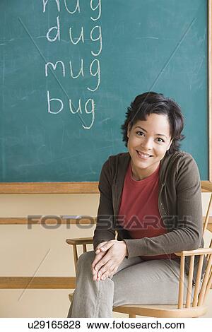 Smiling teacher in classroom View Large Photo Image Stock Photo - Smiling teacher in classroom. Fotosearch