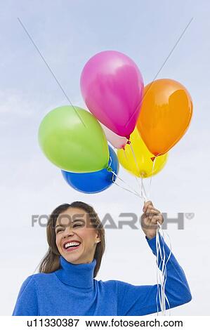 Smiling woman holding balloons View Large Photo Image Stock Photo - Smiling woman holding balloons. Fotosearch