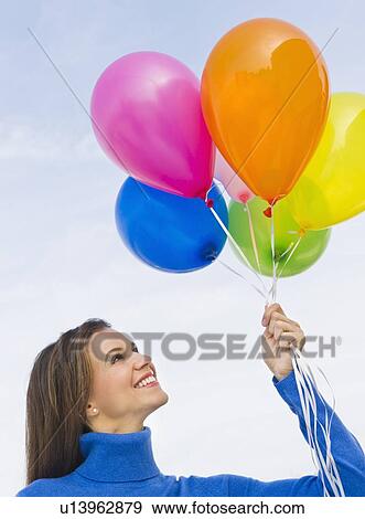 Smiling woman holding balloons View Large Photo Image Stock Photo - Smiling woman holding balloons. Fotosearch