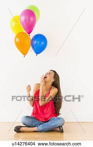 Smiling woman holding balloons, studio shot View Large Photo Image Picture - Smiling woman holding balloons, studio shot. Fotosearch