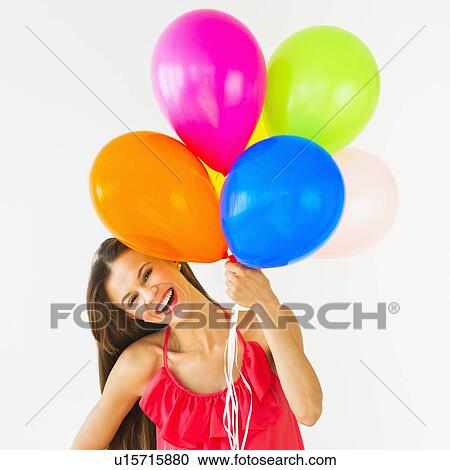 Smiling woman holding balloons, studio shot View Large Photo Image Stock Image - Smiling woman holding balloons, studio shot. Fotosearch