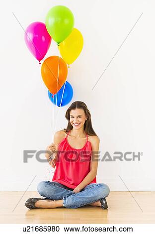 Smiling woman holding balloons, studio shot View Large Photo Image Stock Image - Smiling woman holding balloons, studio shot. Fotosearch
