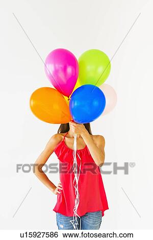 Smiling woman holding balloons, studio shot View Large Photo Image Stock Photograph - Smiling woman holding balloons, studio shot. Fotosearch