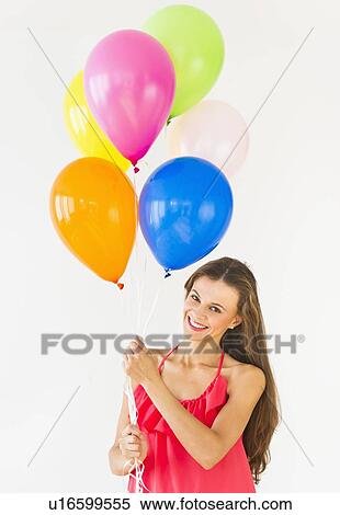 Smiling woman holding balloons, studio shot View Large Photo Image Stock Photography - Smiling woman holding balloons, studio shot. Fotosearch