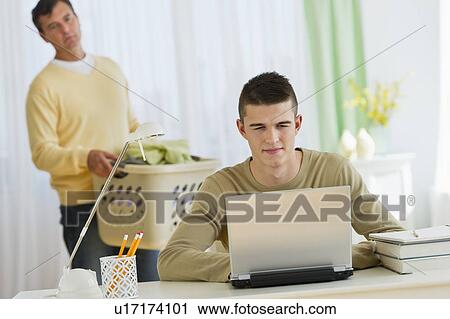 Son (16-17) using laptop being observed by father View Large Photo Image Stock Image - Son (16-17) using laptop being observed by father. Fotosearch