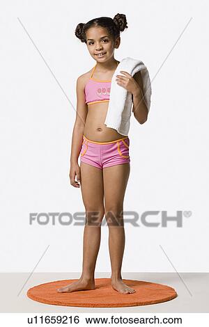 Studio portrait of girl (8-9) in bikini holding towel View Large Photo Image Stock Photograph - Studio portrait of girl (8-9) in bikini holding towel. Fotosearch
