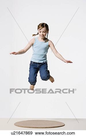 Studio portrait of girl (8-9) jumping View Large Photo Image Stock Photo - Studio portrait of girl (8-9) jumping. Fotosearch