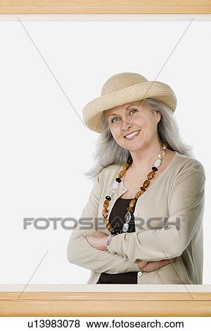 Studio portrait of mature woman behind picture frame View Large Photo Image Stock Photo - Studio portrait of mature woman behind picture frame. Fotosearch
