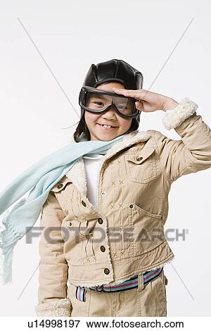 Studio portrait of saluting girl (8-9) wearing aviator's cap and flying goggles View Large Photo Image Stock Photo - Studio portrait of saluting girl (8-9) wearing aviator's cap and flying goggles. Fotosearch