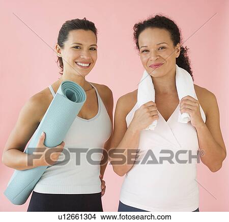 Picture - Studio portrait of women holding exercise mat and towel. Fotosearch