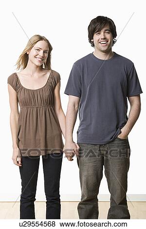 Studio portrait of young couple holding hands View Large Photo Image Stock Photo - Studio portrait of young couple holding hands. Fotosearch