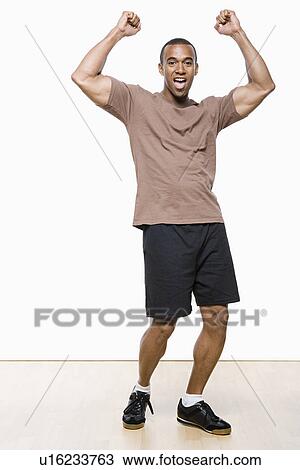 Studio portrait of young man cheering View Large Photo Image Stock Image - Studio portrait of young man cheering. Fotosearch