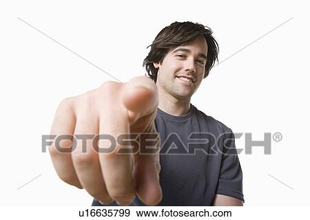 Stock Photo - Studio portrait of young man pointing. Fotosearch