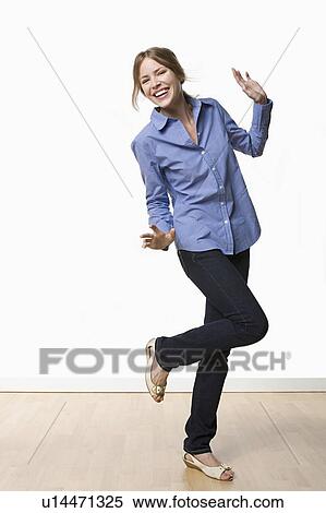 Studio portrait of young woman dancing View Large Photo Image Stock Photography - Studio portrait of young woman dancing. Fotosearch