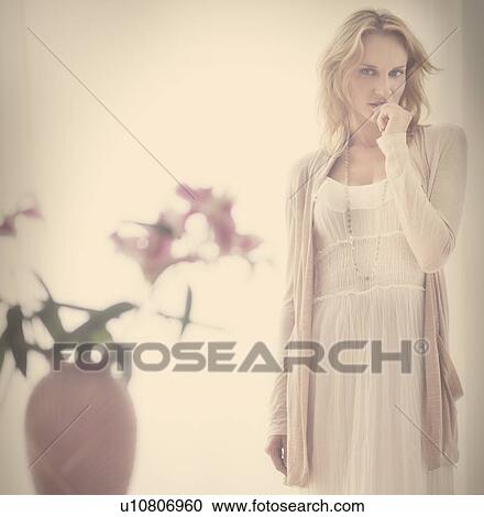 Studio portrait of young woman standing behind vase View Large Photo Image Stock Image - Studio portrait of young woman standing behind vase. Fotosearch